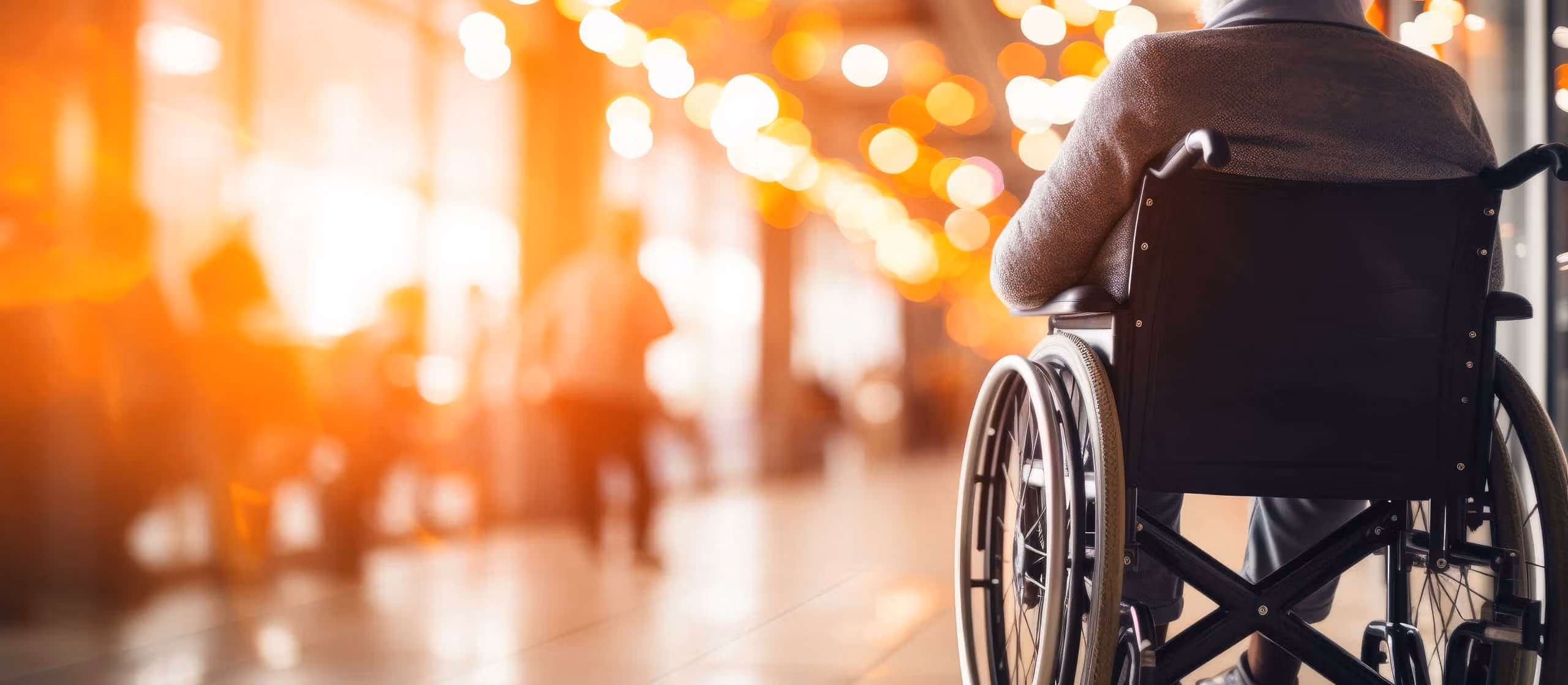 Participant in a wheelchair moving through a sunlit community space